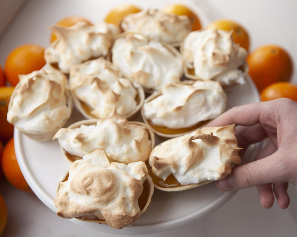 Hand holding an Orange Meringue Pie