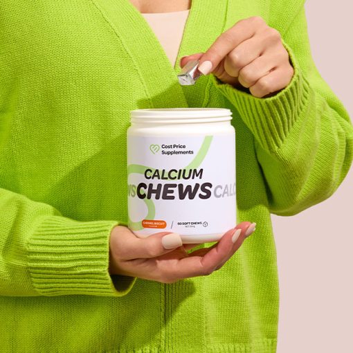 Person in a green cardigan picking a Calcium Chews Sachet by Cost Price Supplements out of the jar