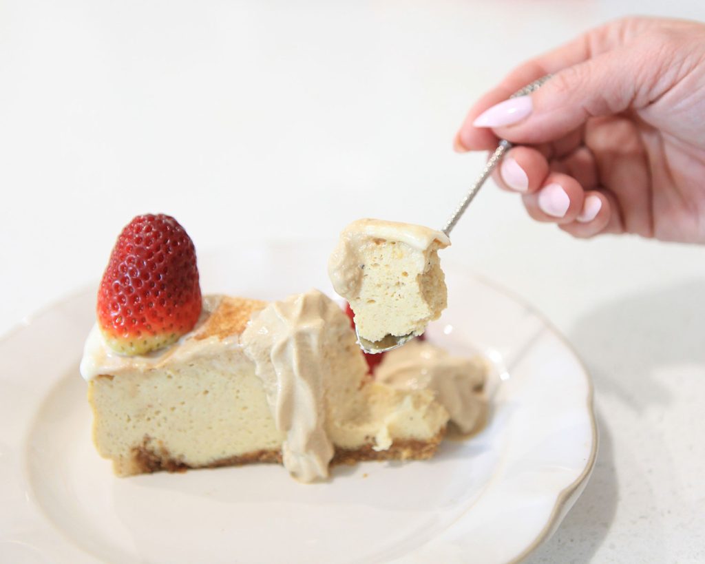 Low Carb Eggnog Cheesecake Recipe - Hand with cheesecake on spoon