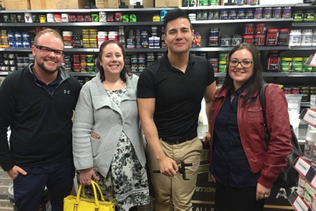 House of Supplements founder Chris Luong (second from the right) wearing a black shirt, posing with three customers inside the Morningside store.