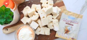 Vanilla Protein Marshmallows Website Header. image of cut-up marshmallows on a wooden serving tray