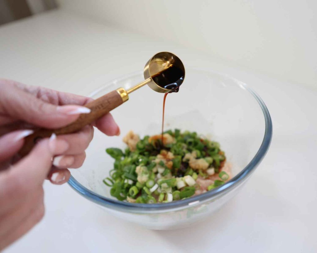 adding sauces to the bowl for the dumpling bake