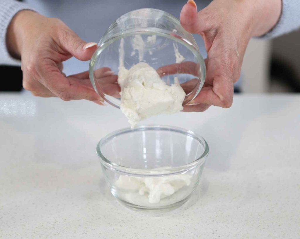 Adding vanilla yoghurt to a bowl for the St Patrick’s Day Protein Cheesecake recipe