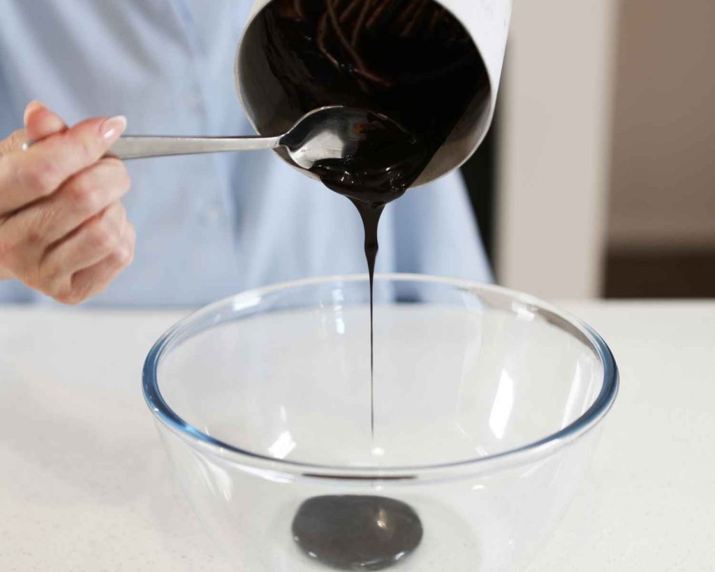 Adding melted ingredients to a bowl for the Chocolate Protein Easter Nests recipe