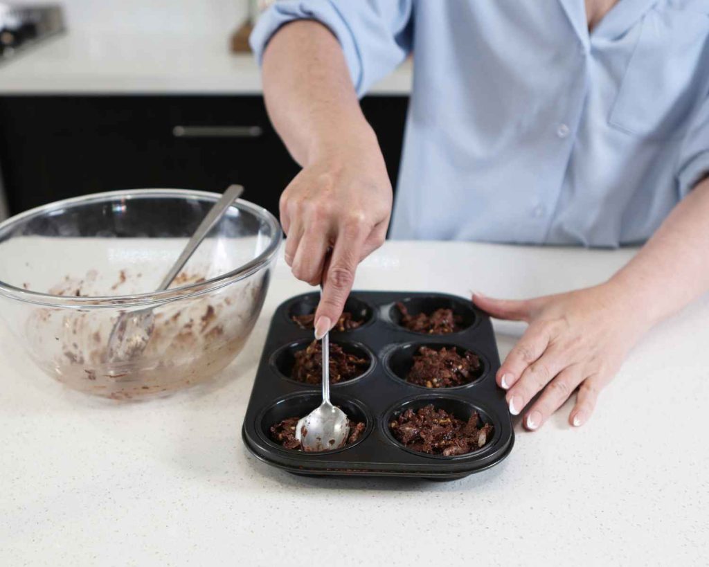 Adding the mixture to the muffin tin for the Chocolate Protein Easter Nests recipe