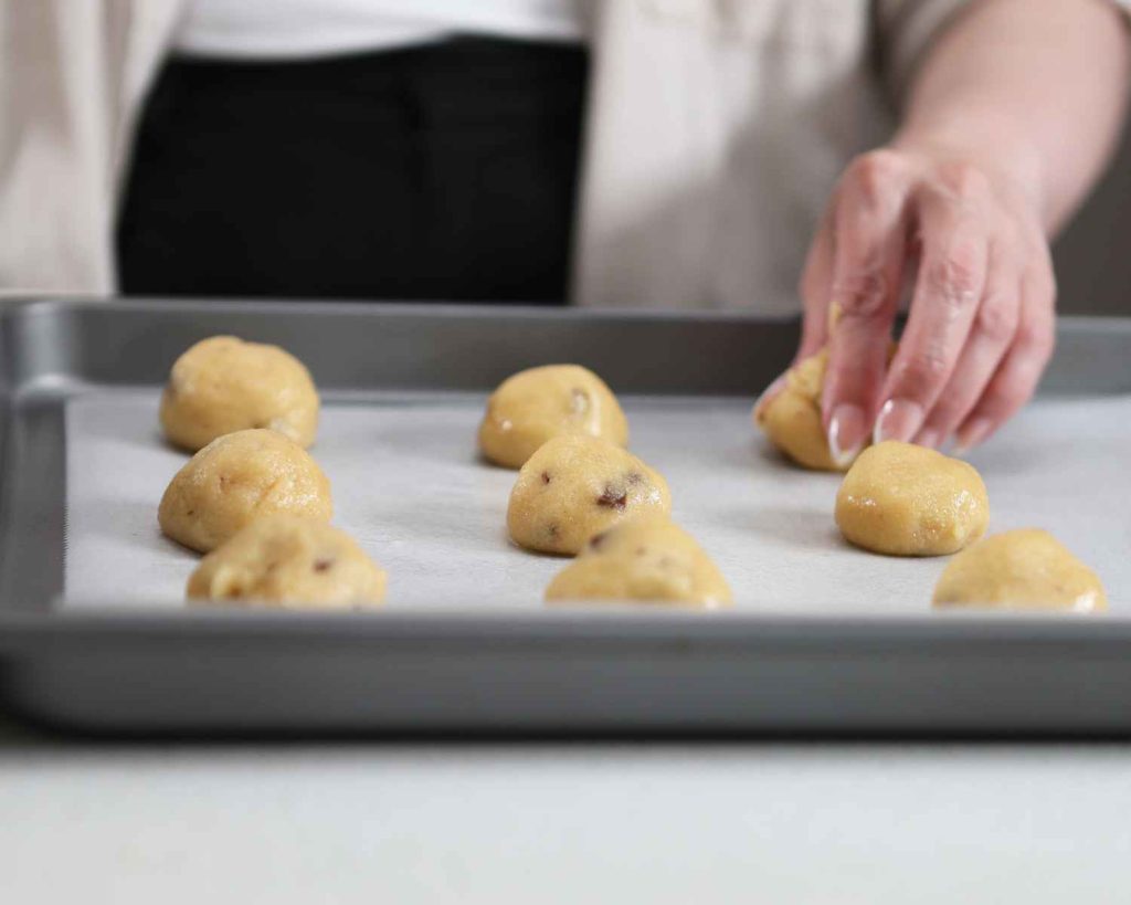 Rolling the cookies into bowls to create Chocolate Chunk Protein Cookies recipe