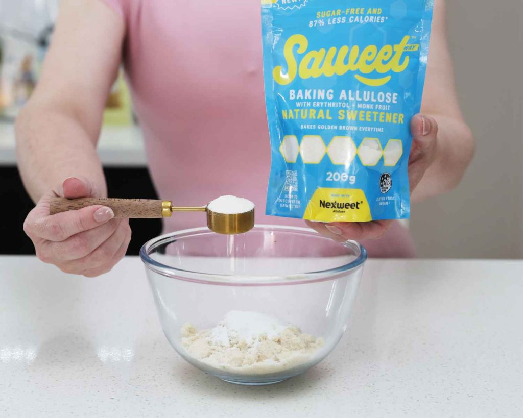 Adding sweetener to Mini Chocolate Protein Cheesecake recipe into a bowl with other ingredients