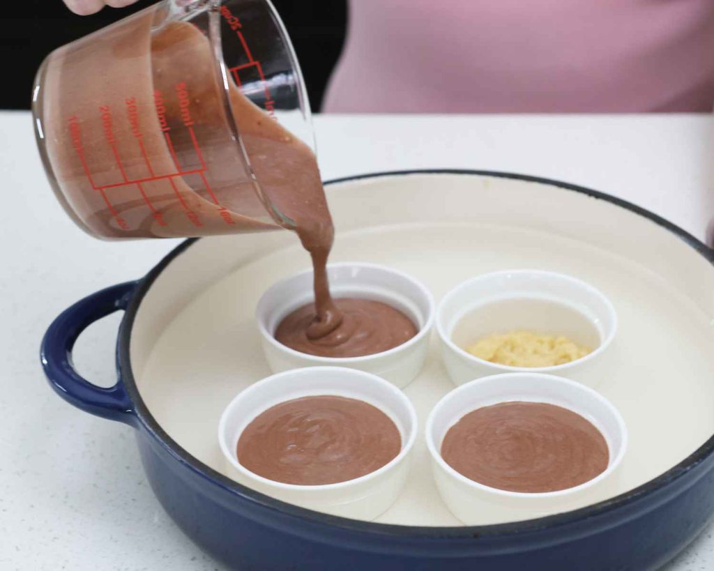 Adding the filling to the ramekins for the Mini Chocolate Protein Cheesecake recipe