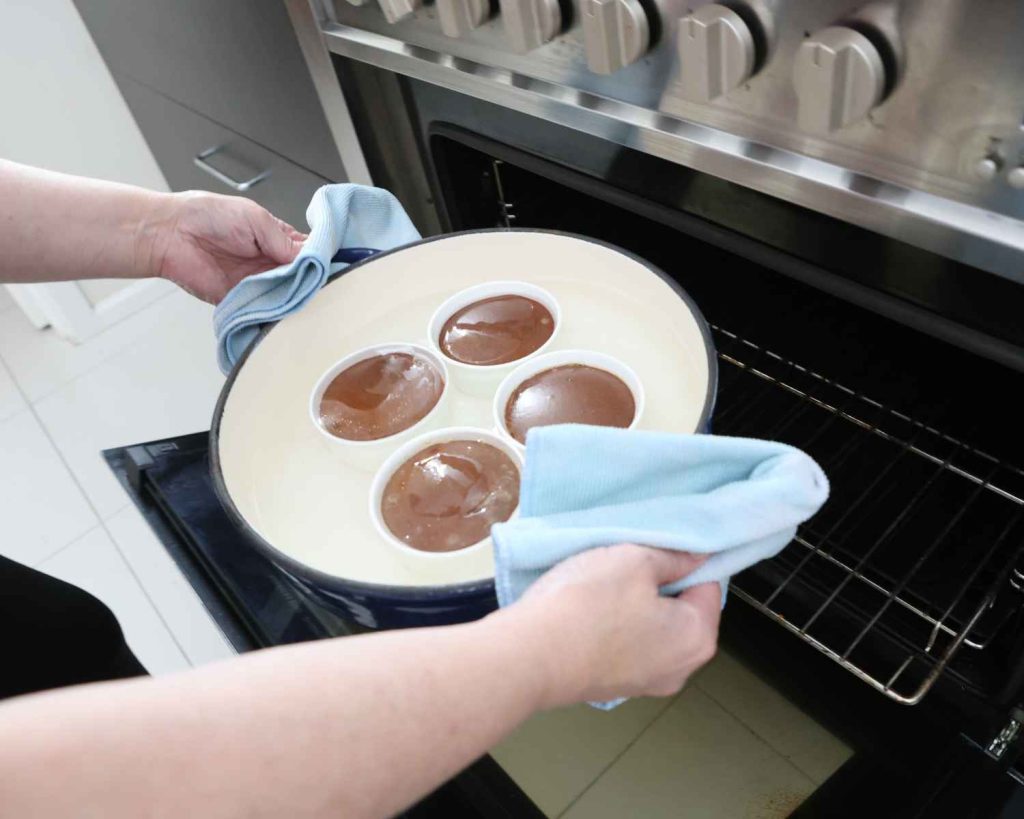 Baking the cheesecakes in the oven for the Mini Chocolate Protein Cheesecake recipe