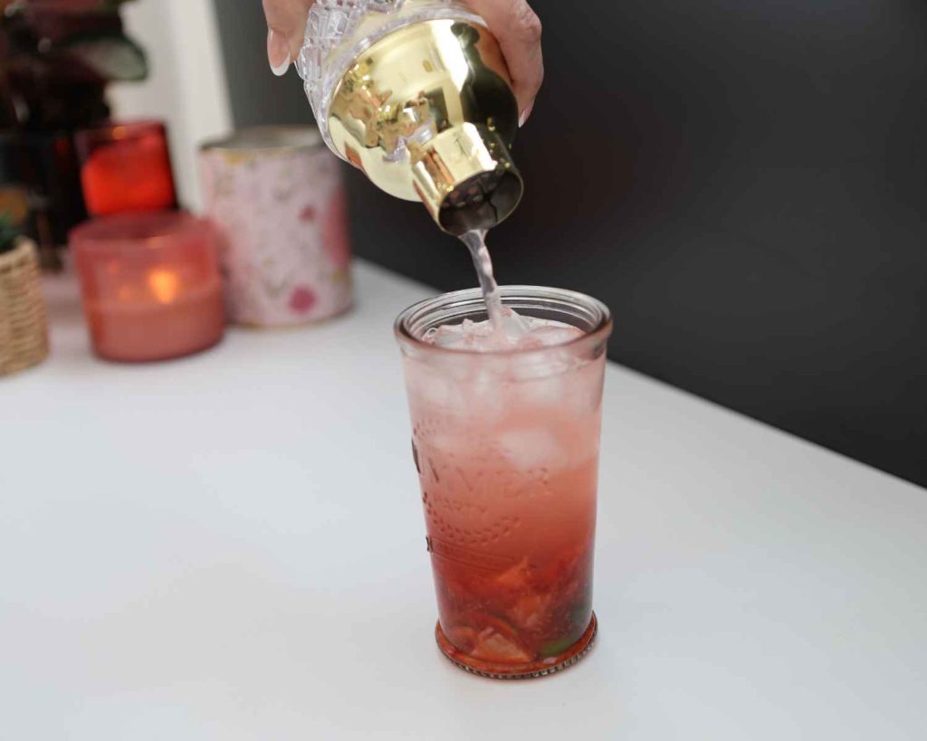 Adding protein water to the Strawberry Mojito Protein Mocktail 