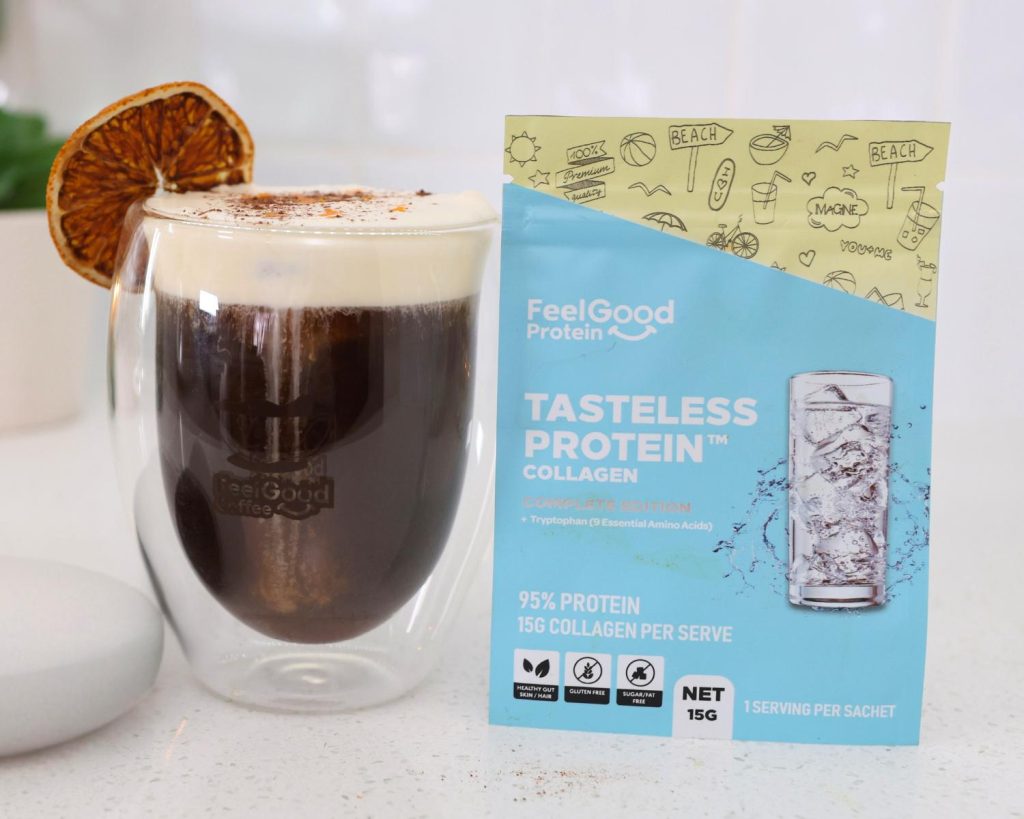 Front-facing photo of a Mont Blanc Proffee in a glass coffee cup next to a sachet of Tasteless Protein Collagen by Feel Good Protein. 