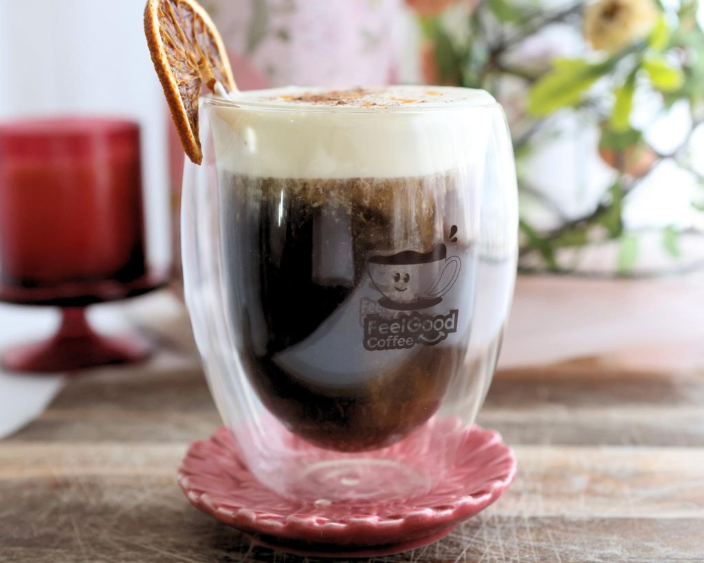 Front-facing photo of a Mont Blanc Proffee in a glass coffee cup resting on a small red plate. 