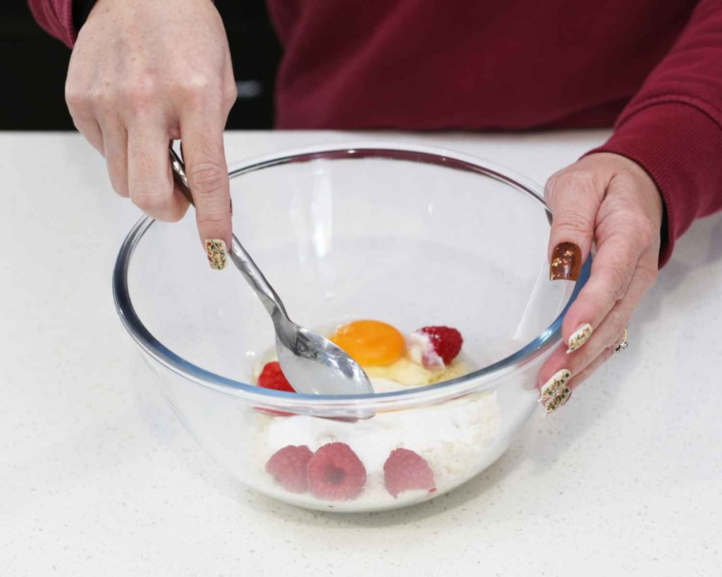 Mixing in the eggs and raspberries for the cookies