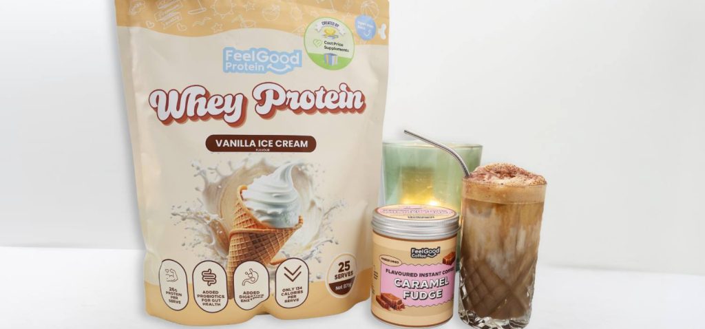 Front-facing photo of a Whey Protein by Feel Good Protein bag next to a metal container reading ‘Flavoured Instant Coffee Rum’, and a Caramel Brown Sugar Shaken Espresso in a glass cup on a white benchtop.