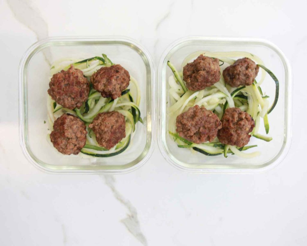 Adding meatballs on top of the zucchini noodles