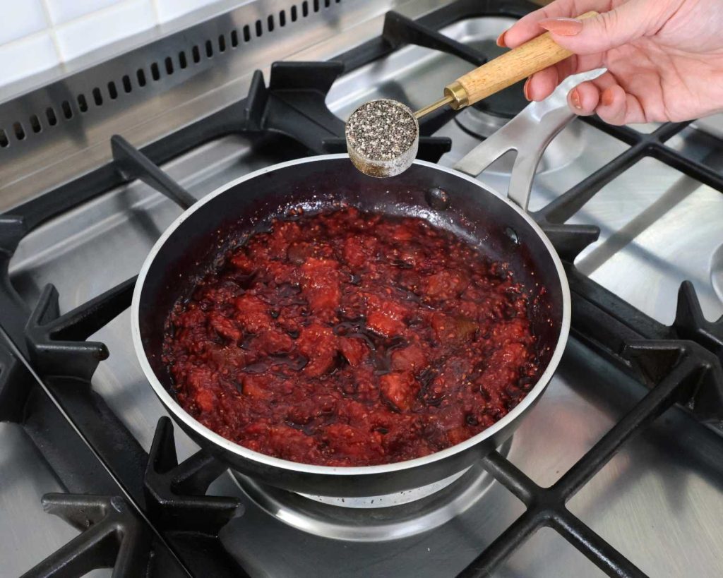Adding chia seeds to the fig and raspberry jam