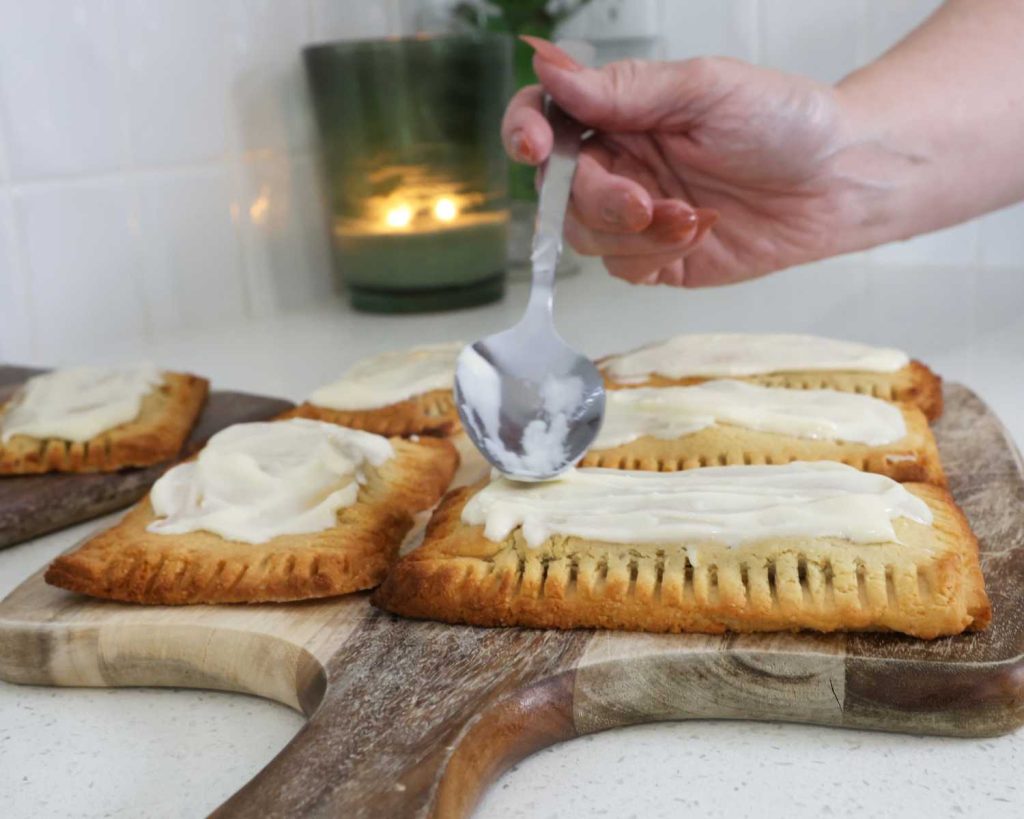 Adding the topping to the cooked and cooled Fig & Raspberry Protein Pop-Tarts