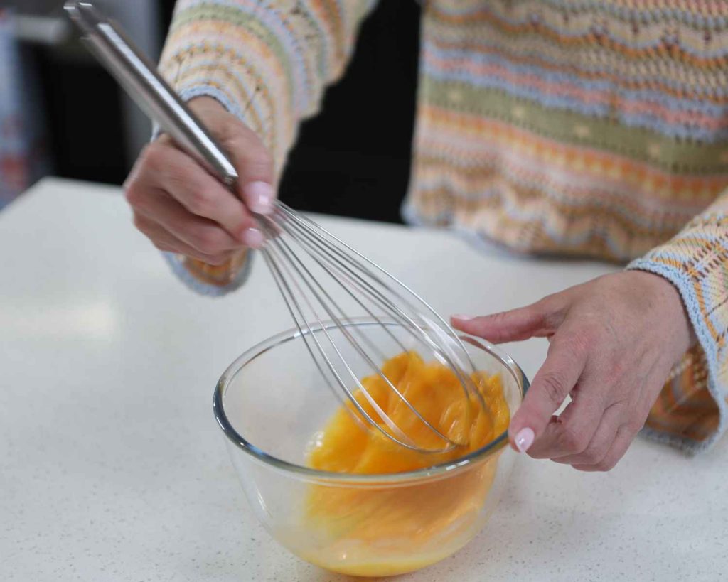 Whisking 3 eggs for the recipe